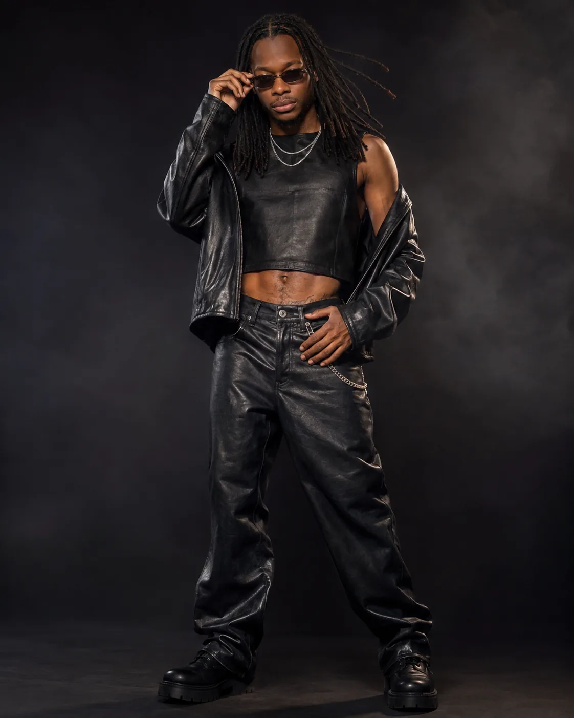 Trey Trizzy in an all-black leather editorial look against a dark studio background.